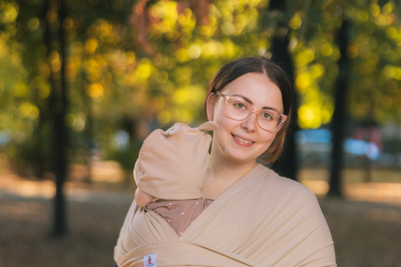 Mama sa bebom u bež marami, pravilan položaj
